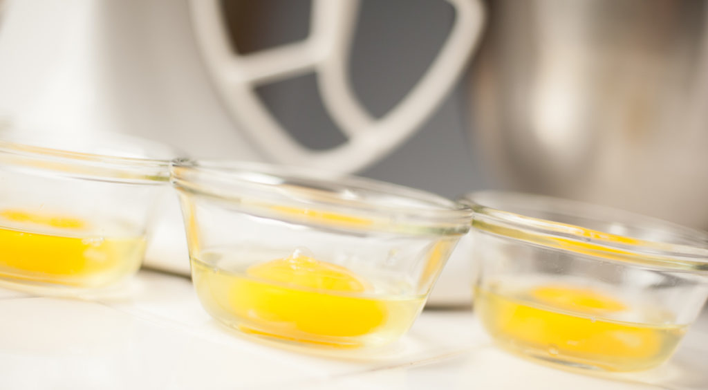 3 eggs in pyrex custard cups with kitchenaid stand mixer in background