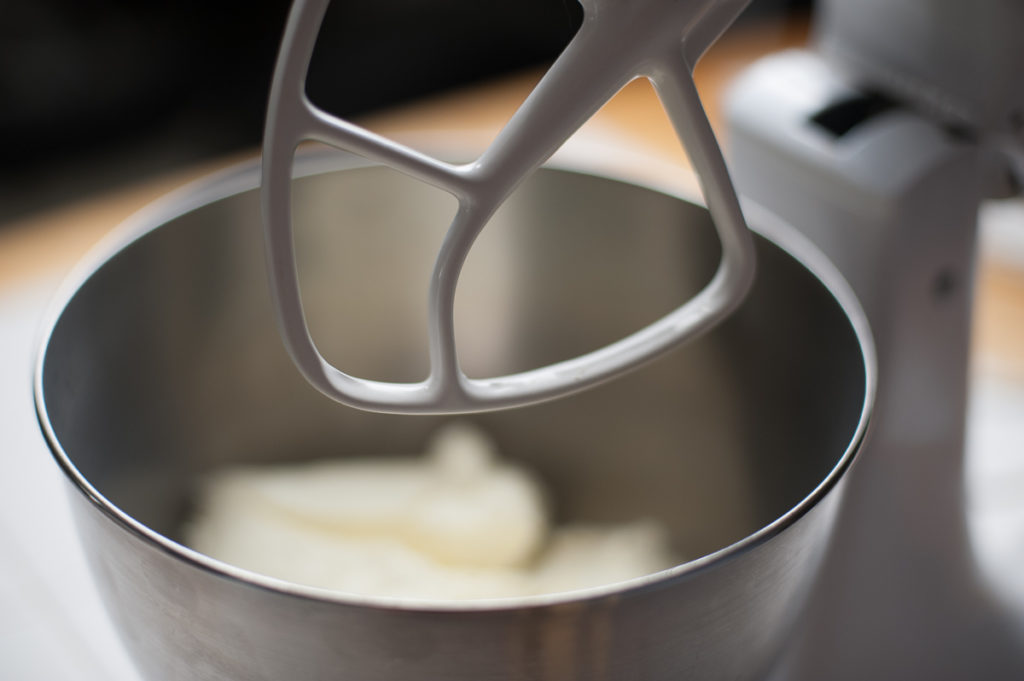 Kitchen Aid stand mixer with Philly cream cheese in the mixing bowl ready to start mixing