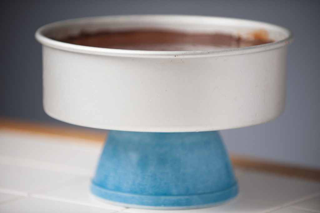 chocolate to the 4th power cheesecake sitting on top of inverted medium bowl