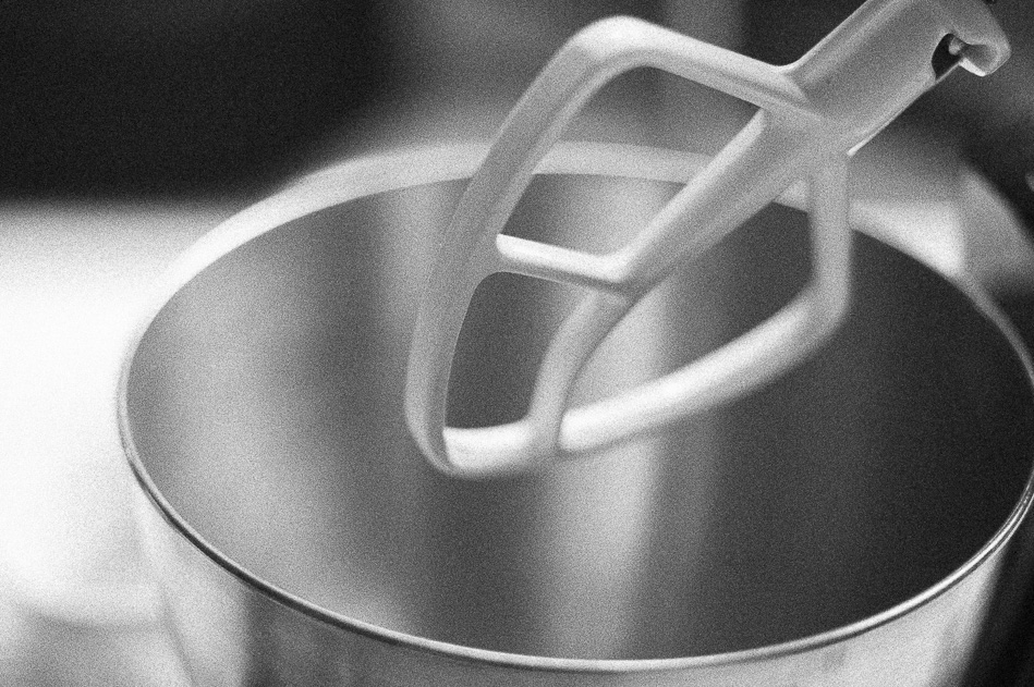 black and white picture of Kitchen Aid stand mixer paddle over mixing bowl