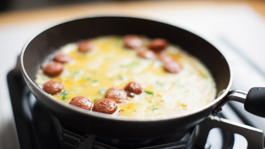 EGGS ON HOTDOG COOKING IN SAUTE PAN